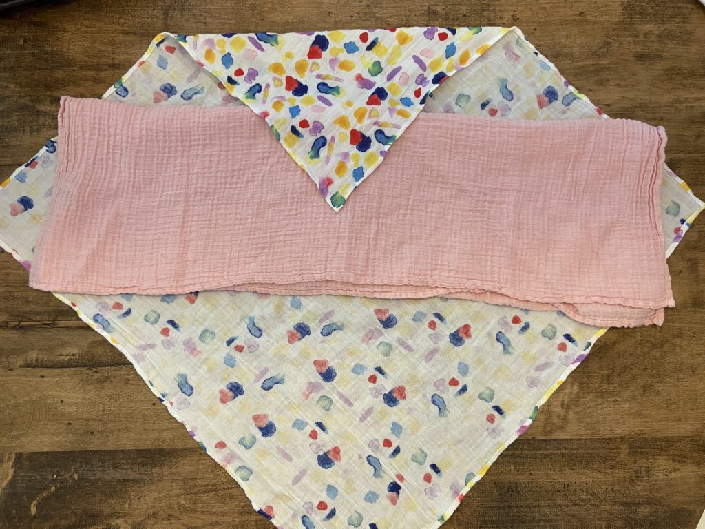 Use a rectangular muslin blanket under your main swaddle blanket to help hold down your little escape artist's arms.